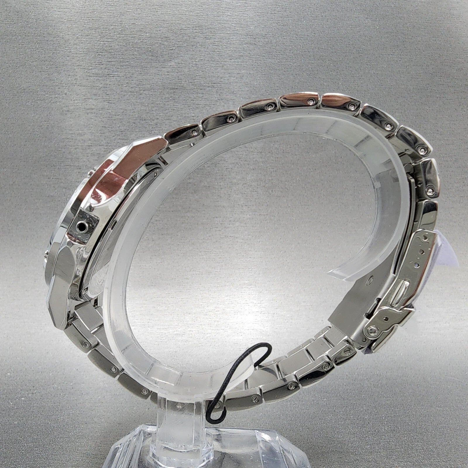 Silver stainless steel watch bracelet on display stand against gray background