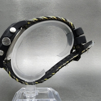 Side view of black digital watch with fabric band on display stand, gray background