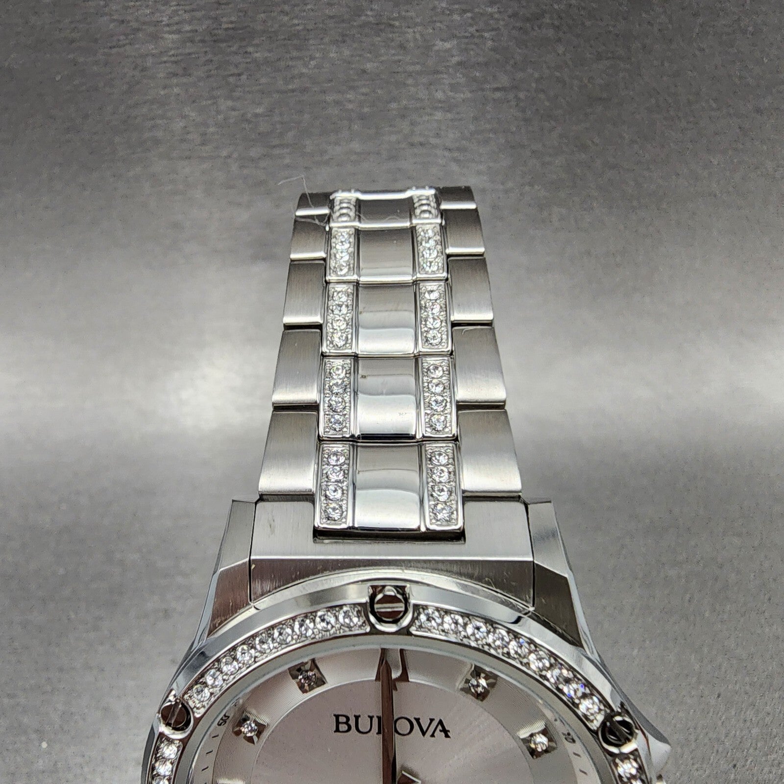 Bulova silver stainless steel watch with crystal-accented band and bezel, close-up view