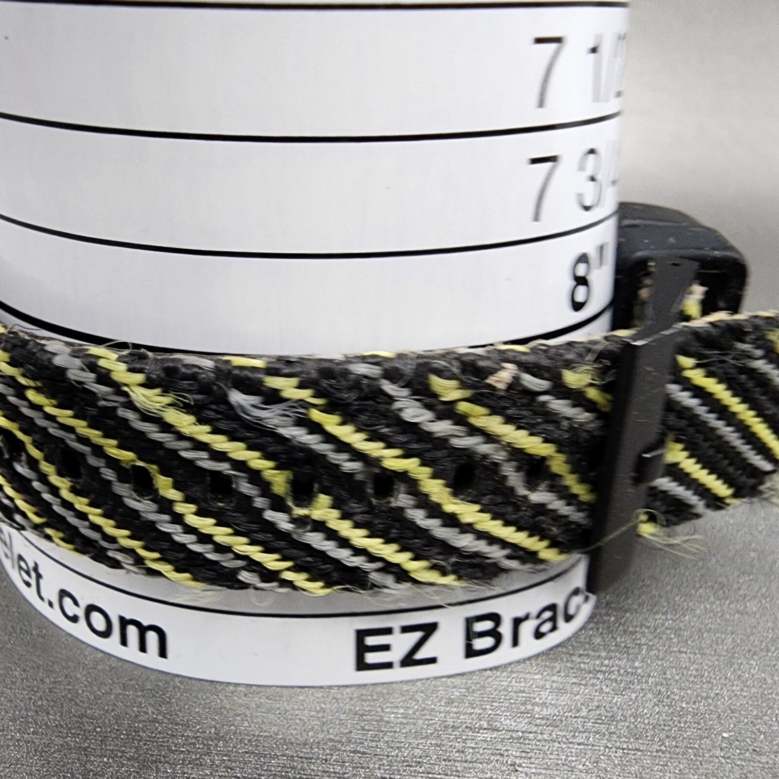 Black and yellow woven bracelet on measurement tool, EZ Bracelet sizer visible