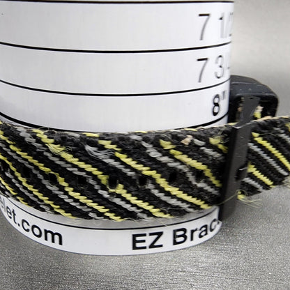 Black and yellow woven bracelet on measurement tool, EZ Bracelet sizer visible