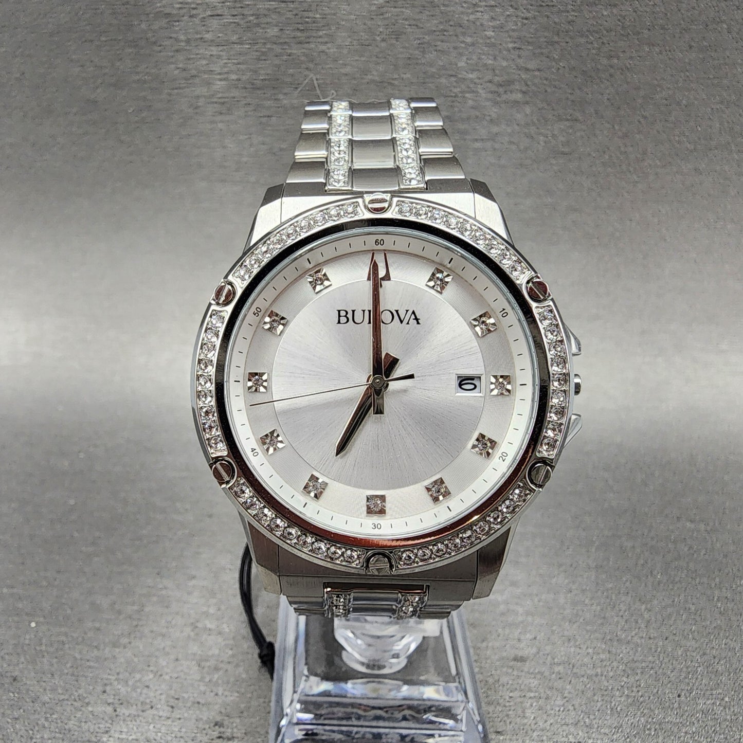 Bulova silver wristwatch with crystal accents, stainless steel band, and date display on stand