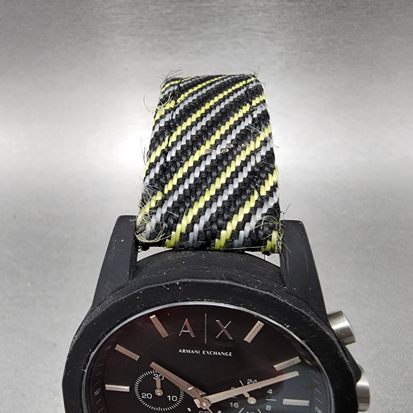 Armani Exchange black watch with striped nylon band in black, yellow, and white