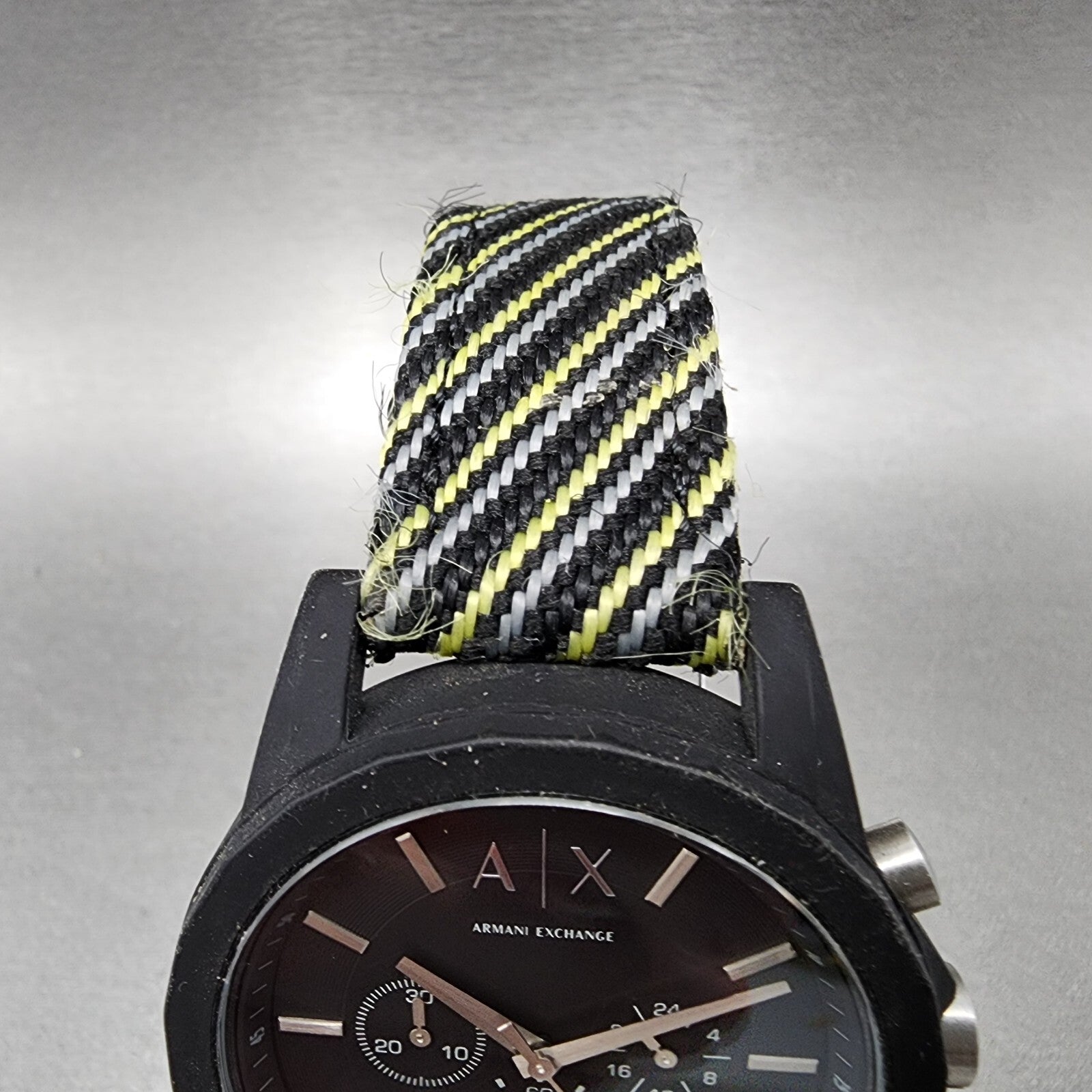 Armani Exchange black watch with striped nylon band in black, yellow, and white